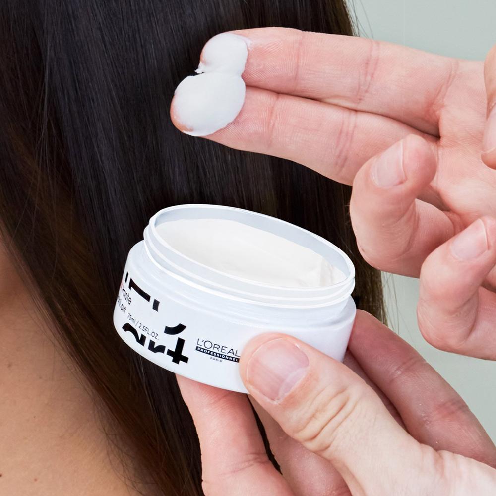 Malé množstvo L'Oréal matnej pasty na vlasy na prstoch pred aplikáciou