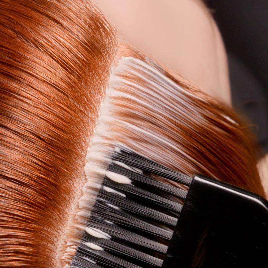 Natieranie profesionálnej farby na vlasy žene s ryšavými vlasmi